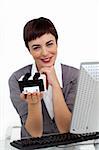 Glowing businesswoman holding a business card holder looking at the camera