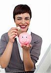 Joyful Female executive saving money in a piggybank isolated on a white background