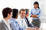 Confident businesswoman with folded arms doing a presentation to her team