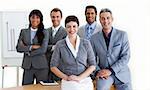 Confident multi-ethnic business people around a conference table smiling at the camera