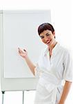 Cheerful businesswoman ponting at a board against a white background