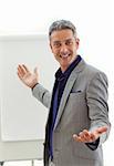 Charming businessman pointing at a board against a white background