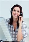 Radiant businesswoman with headset on working at a computer in a call-center