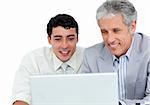 Assertive business co-workers using a laptop against a white background