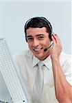 Assertive businessman using headset working at a computer