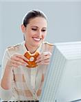 Portrait of a caucasian businesswoman eating donnuts in her office in a company