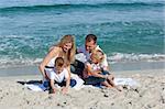 Happy family playing on the sand at the beach
