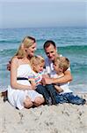 Portrait of an affectionate family sitting on the sand at the beach