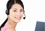 Smiling businesswoman with headset on against a white background