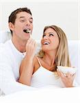 Smiling couple having breakfast against a white background