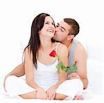 Pretty couple kissing each other against a white background