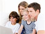 Smiling family surfing on internet against a white background
