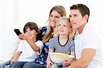Smiling family watching a film at television against a white background