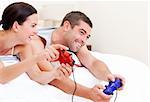 Joyful couple playing video games against a white background