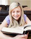 Happy woman reading a book in the living-room