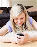 Bright woman sending a text in the living-room