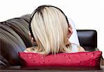 Young woman using headphones on a sofa