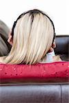 Concentrated woman using headphones on a sofa