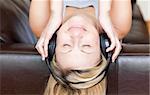 Calm woman using headphones on a sofa