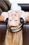 Attractive woman using headphones on a sofa