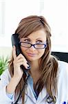 Radiant female doctor talking on the phone in her office