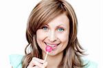 Attractive woman holding a lollipop against a white background