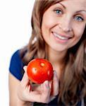Smiling woman holding a tomato isolated on a white background