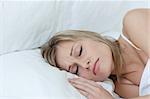 Blond woman sleeping in a bed at home