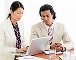 Concentrated business people working at a laptop in a meeting