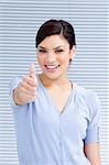Cheerful businesswoman with a thumb up at work