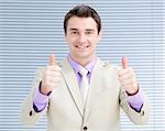 Successful businessman with thumbs up in the office