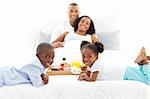 Jolly family having breakfast in the bedroom at home