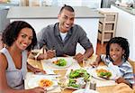 Ethnic couple dining with their son in the kitchen