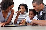 Happy afro-american family eating homemade biscuits in the kitchen