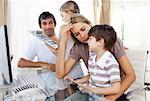 Parents helping their children do homework in the living-room