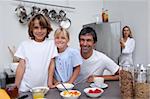 Smiling family having breakfast  in the kitchen