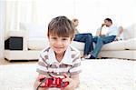 Adorable little boy playing video games lying on the floor