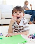 Close-up of little boy drawing lying on the floor in the living room