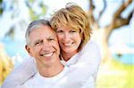 Close-up portrait of a mature couple smiling and embracing. Focus on the woman.