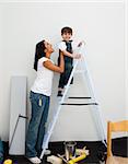 Smiling little boy climbing a ladder while renovating a room