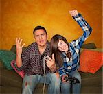 Attractive Hispanic Man and Girl Playing a Video Game with Handheld Controllers