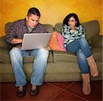 Hispanic Couple on Green Couch with Computer