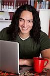 Handsome Native American man with laptop and red mug