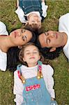 Merry family sleeping lying on the grass in a park