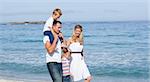 Lively family walking on the sand at the beach