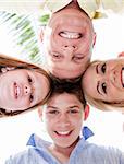 Happy family smiling and joining their heads together and looking at the camera