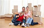 Cheerful family relaxing sitting on the floor while moving house