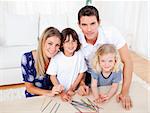 Cheerful family playing mikado in the living room at home