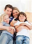 United family watching television sitting on sofa at home