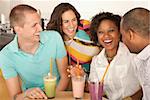 Two couples at a cafe drinking frozen beverages. Horizontal shot.